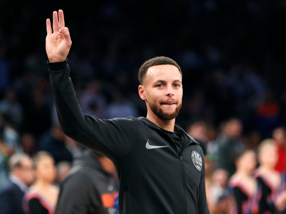 Stephen Curry holds up three fingers during warmups before a game.