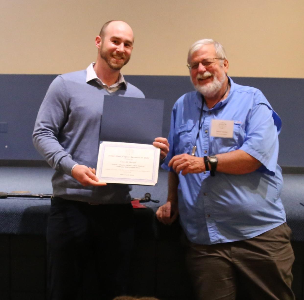 Florida Atlantic University Harbor Branch Oceanographic Institute faculty member Dennis Hanisak, right, presents Clark Morgan with an award in January 2024.