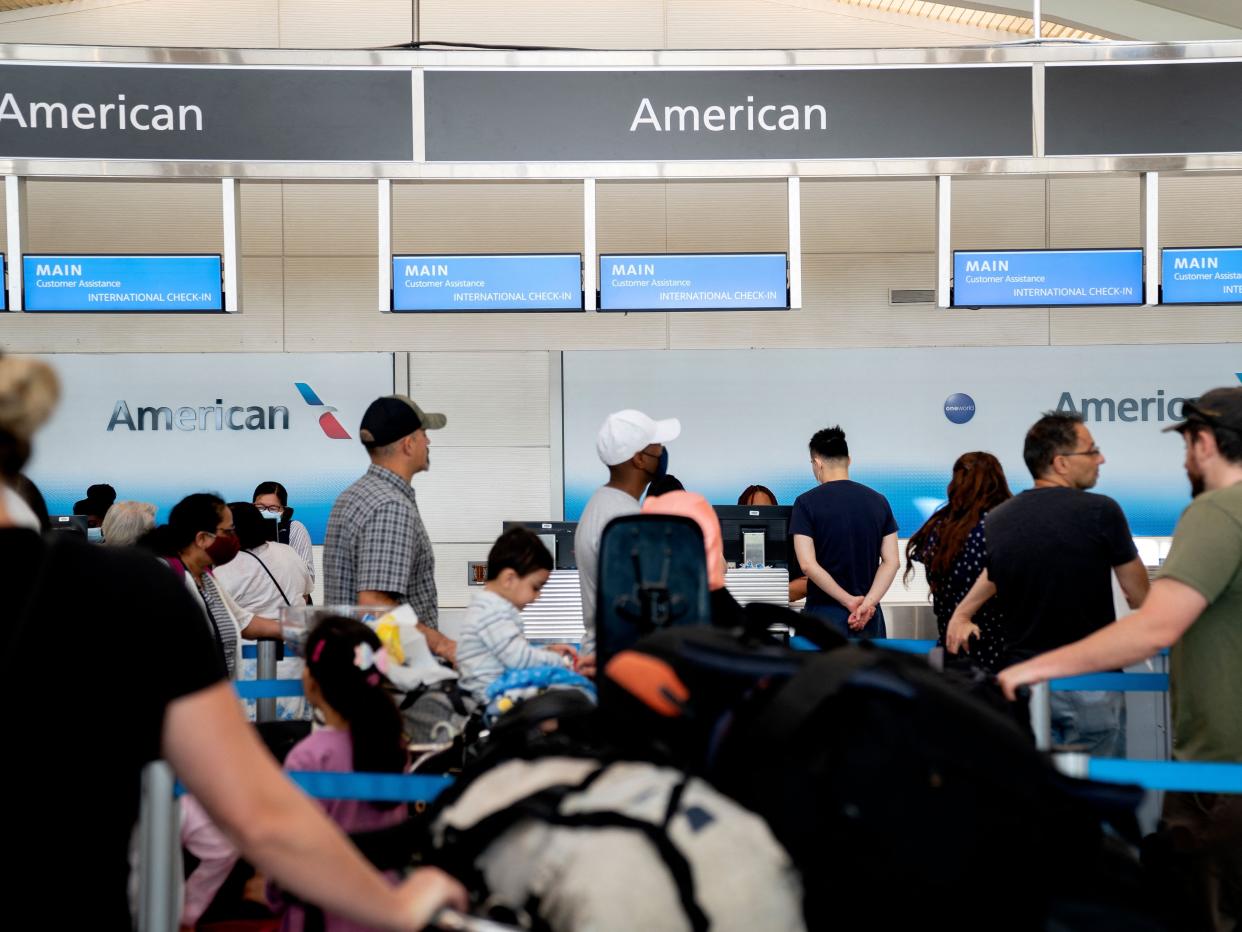 Travelers wait in line at an American Airlines counter at Ronald Reagan Washington National Airport in Arlington, Virginia, on July 2, 2022