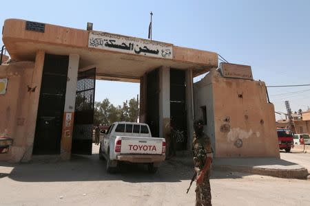 A Kurdish fighter stands with his weapon on the entrance of Hasaka Prison in the Ghwairan neighborhood of Hasaka, Syria, August 23, 2016.REUTERS/Rodi Said