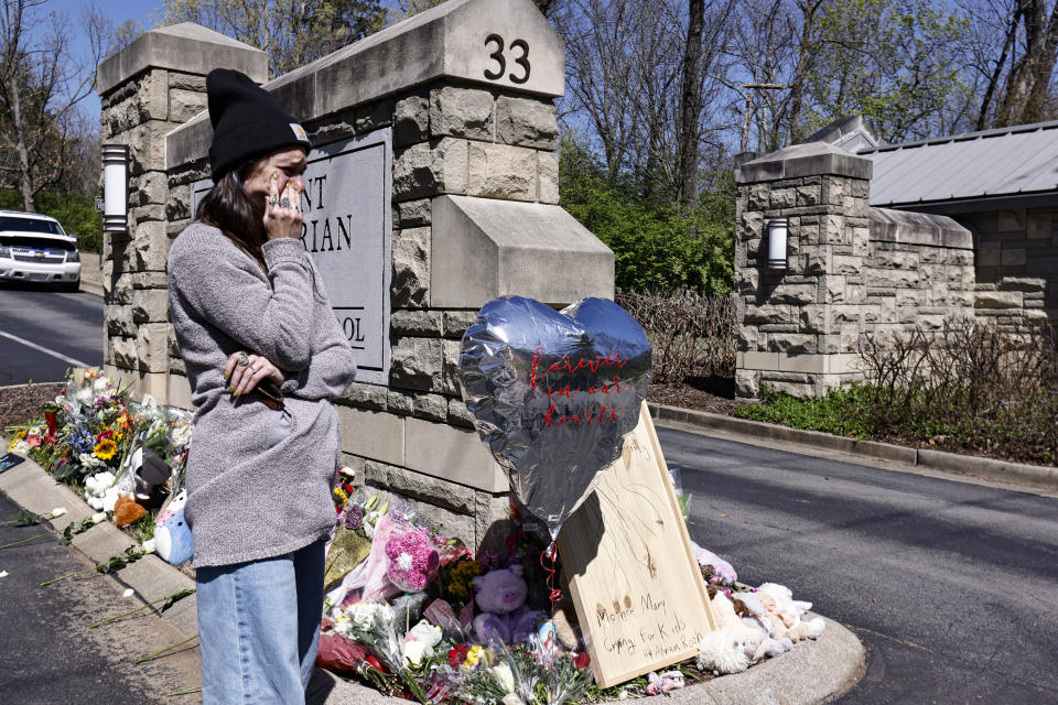 A woman wipes away tears as she visits a memorial at the entrance to The Covenant School on Wednesday, March 29, 2023, in Nashville, Tenn. (AP Photo/Wade Payne)