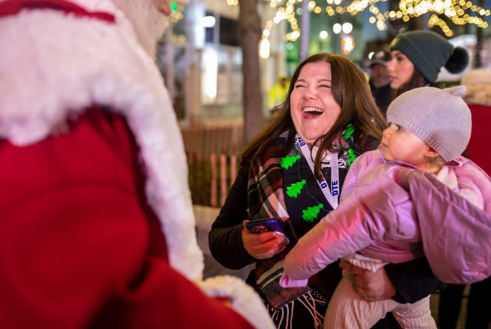 Stephanie Hoenig smiles as she carries her daughter in Campus Martius Park during the 20th Annual Tree Lighting in downtown Detroit on Friday, Nov. 17, 2023.