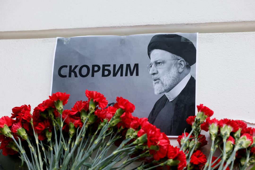 A view shows flowers outside the Iranian embassy placed to pay tribute to Iran's President Ebrahim Raisi, Foreign Minister Hossein Amirabdollahian and other victims of a recent helicopter crash in mountainous terrain near Iran's border with Azerbaijan, in Moscow, Russia, May 20, 2024. A placard with a portrait of Iran's President Ebrahim Raisi reads: 