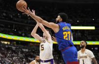 Denver Nuggets guard Jamal Murray (27) goes up to shoot against Los Angeles Lakers guard Austin Reaves (15) during the second half in Game 1 of an NBA basketball first-round playoff series Saturday, April 20, 2024, in Denver. (AP Photo/Jack Dempsey)