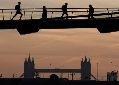 Workers cross the Millennium footbridge at dawn with Tower Bridge seen behind in London, Britain, December 19, 2017. REUTERS/Toby Melville