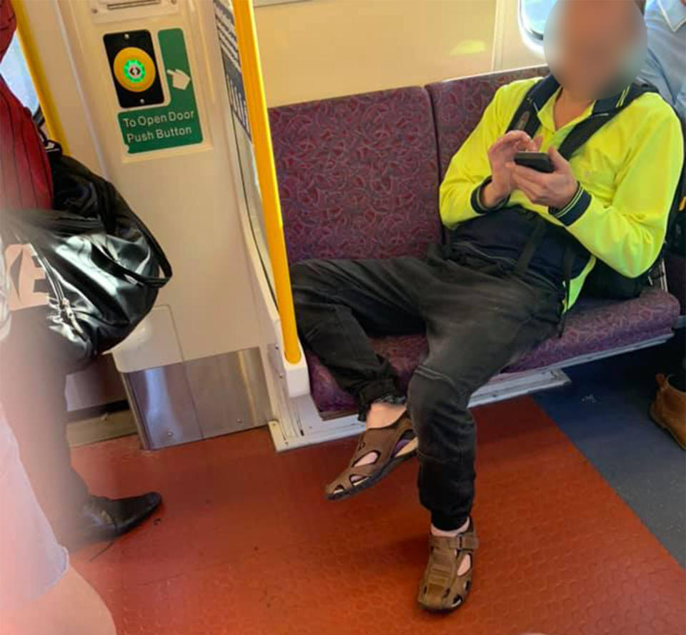 A man in high visibility uniform is lying across two seats in a train carriage, accused of refusing to move over for a pregnant woman. .