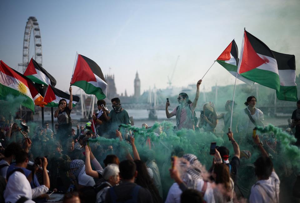 Protesters wave Palestinian flags and brandish a smoke flare during a Pro-Palestinian demonstration on Waterloo Bridge, in London (AFP via Getty Images)