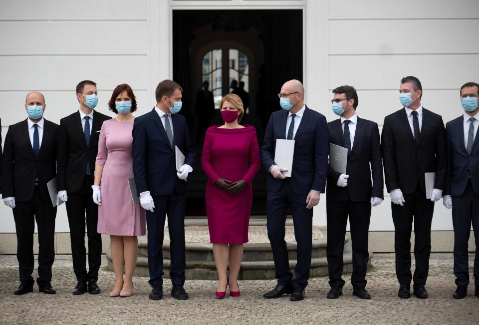 TOPSHOT - Newly appointed Slovak Prime Minister Igor Matovic (C-L), leader of the OLaNO anti-graft party and President Zuzana Caputova (C-R) pose for a family picture with Ministers after a swearing in ceremony of the new four-party coalition government on March 21, 2020 outside of the Presidential palace in Bratislava. - The ceremony was held without members of the press and all appointed government members wore gloves and face mask to prevent the spread of novel coronavirus. (Photo by JOE KLAMAR / AFP) (Photo by JOE KLAMAR/AFP via Getty Images)