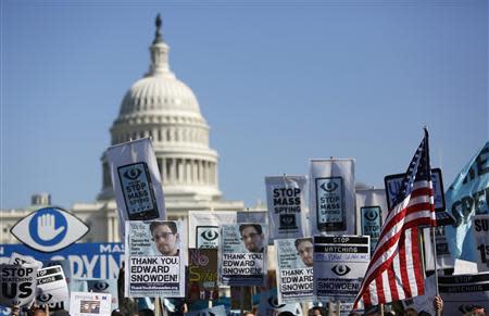 Demonstrators hold up their signs during the "Stop Watching Us: A Rally Against Mass Surveillance" march near the U.S. Capitol in Washington, October 26, 2013. REUTERS/Jonathan Ernst