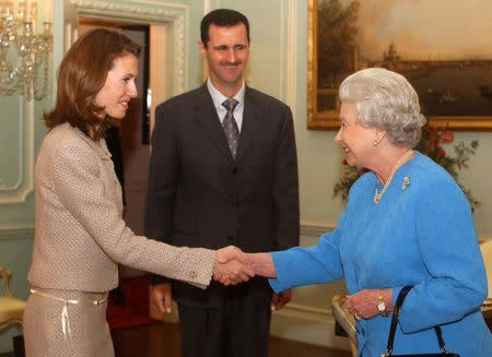 Britain's Queen Elizabeth II (R) greets Syria's President Bashar al-Assad (C) and his wife Asma at Buckingham Palace in London December 17, 2002. REUTERS/Kirsty Wigglesworth/Files