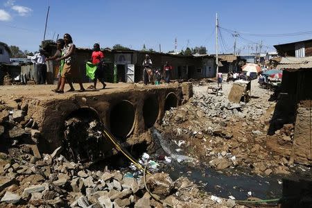 People walk near open sewers in the Kibera slum of Kenya's capital Nairobi February 26, 2015. REUTERS/Darrin Zammit Lupi