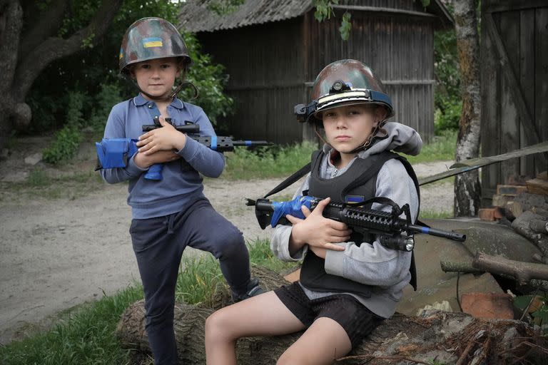 Los niños Ucranianos Andrii (12 años) y su amigo Valentyn (6 años), posan con armas de juguete en un inventado "checkpoint" muy cercanos a su escuela en la ciudad de Stoyanka.