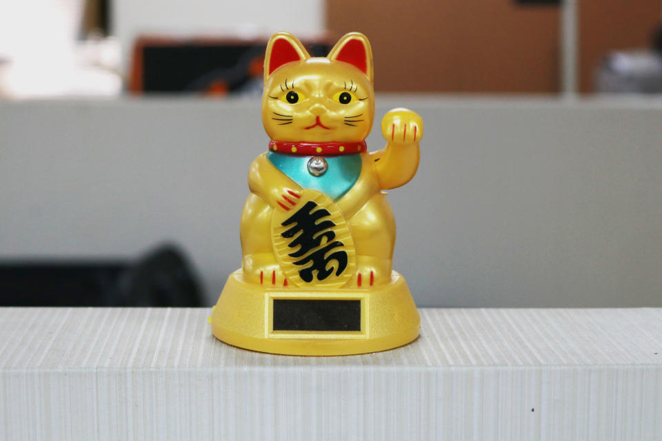 These decorations are called maneki neko or often referred to as fortune cats. Maneki neko himself must always be in business places.This little cat statue is very popular in Japanese and Chinese