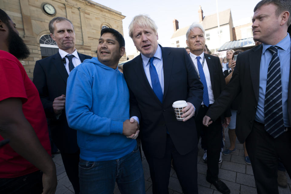 Britain's Prime Minister Boris Johnson shakes hands with a member of the public during a visit to Doncaster Market, in Doncaster, Northern England, Friday Sept. 13, 2019. Johnson will meet with European Commission president Jean-Claude Juncker for Brexit talks Monday in Luxembourg. The Brexit negotiations have produced few signs of progress as the Oct. 31 deadline for Britain’s departure from the European Union bloc nears. ( AP Photo/Jon Super)