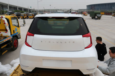 Singulato workers unwrap a concept car, dubbed the iC3, which is based on a discontinued EV of Toyota, in preparation for the upcoming auto show in Shanghai, China April 14, 2019. REUTERS/Norihiko Shirouzu