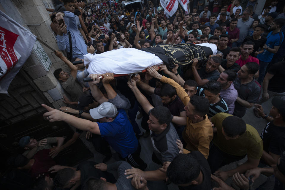 Palestinian mourners carry the bodies of victims killed earlier in an Israeli airstrike, during their funeral in Gaza City, Friday, Aug. 5, 2022. Palestinian officials say Israeli airstrikes on Gaza have killed several people, including a senior militant, and wounded 40 others. (AP Photo/Fatima Shbair)