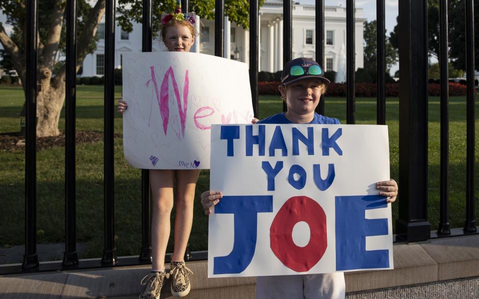 Kids hold banners outside the White House