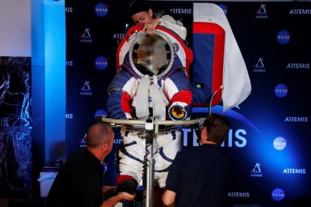 Advanced Space Suit Engineer at NASA Kristine Davis takes off the new xEMU space suit for the next astronaut to the moon by 2024, during its presentation at NASA headquarters in Washington