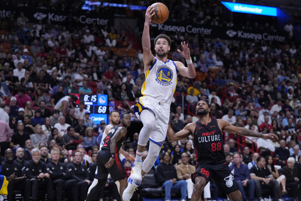 Golden State Warriors guard Klay Thompson (11) goes up for a shot against Miami Heat guard Patty Mills (88) during the second half of an NBA basketball game, Tuesday, March 26, 2024, in Miami. (AP Photo/Wilfredo Lee)