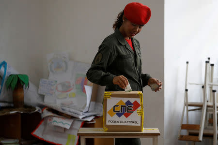 A Venezuelan soldier casts her vote at a polling station during the municipal legislators election in Caracas, Venezuela December 9, 2018. REUTERS/Marco Bello