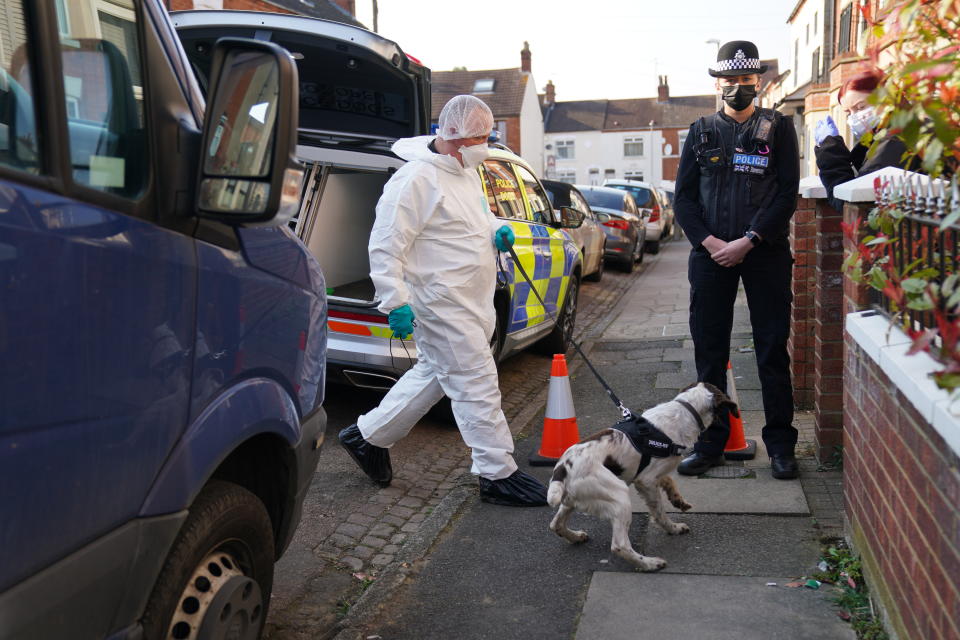 Forensic officers entry the property with a police dog in Moore Street, Kingsley, Northampton following a discovery of a body in a rear garden. The remains are expected be taken to Leicester where they will be forensically examined by a Home Office pathologist but are believed to be that of a missing 42-year-old male. The investigation was mounted following the arrest of Fiona Beal, 48, at a hotel in Cumbria early on Wednesday morning. She has now been charged with murder. Picture date: Sunday March 20, 2022.