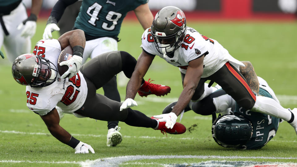 Tampa Bay Buccaneers running back Giovani Bernard (25) gets tripped up as wide receiver Breshad Perriman (16) knocks down Philadelphia Eagles free safety Marcus Epps (22) during the second half of an NFL wild-card football game Sunday, Jan. 16, 2022, in Tampa, Fla. (AP Photo/Mark LoMoglio)