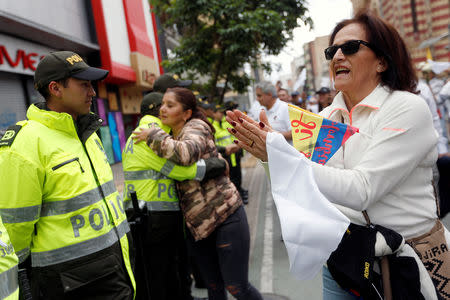 A woman applauds police officers during a rally against violence, following a car bomb explosion, in Bogota, Colombia January 20, 2019. REUTERS/Luisa Gonzalez