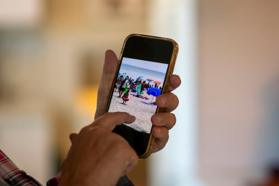 Patricia Mason-Levasseur looks at a photograph on her phone she took of Crystal Beach this summer.