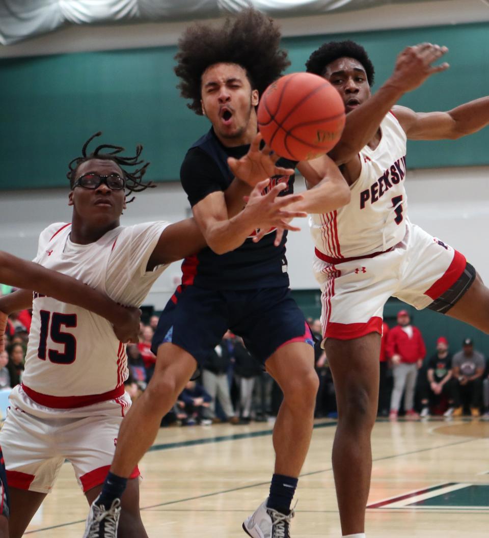 Peekskill's Marquette Webster (15) and Lavon Mott (5) battle for a rebound with BinghamtonÕs Tayshaun Brooks (12) during the state Class AA subregional playoff game at Yorktown High School March 6, 2024. Peekskill won the game 53-52.