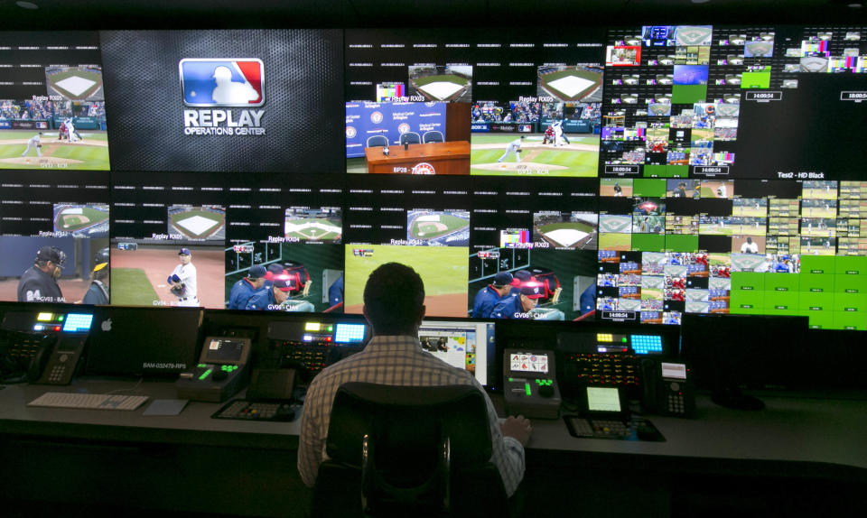 A technician works in front of a bank of television screens during a preview of Major League Baseball's Replay Operations Center, in New York, Wednesday, March 26, 2014. Less than a week before most teams open, MLB is working on the unveiling of its new instant replay system, which it hopes will vastly reduce incorrect calls by umpires. (AP Photo/Richard Drew)