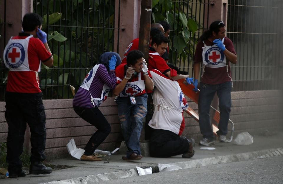 Philippine Red Cross personnel react after a mortar attack by Muslim rebels, near the scene of fighting between government soldiers and Muslim rebels from the Moro National Liberation Front (MNLF) in Zamboanga city in southern Philippines September 13, 2013. (REUTERS/Erik De Castro)