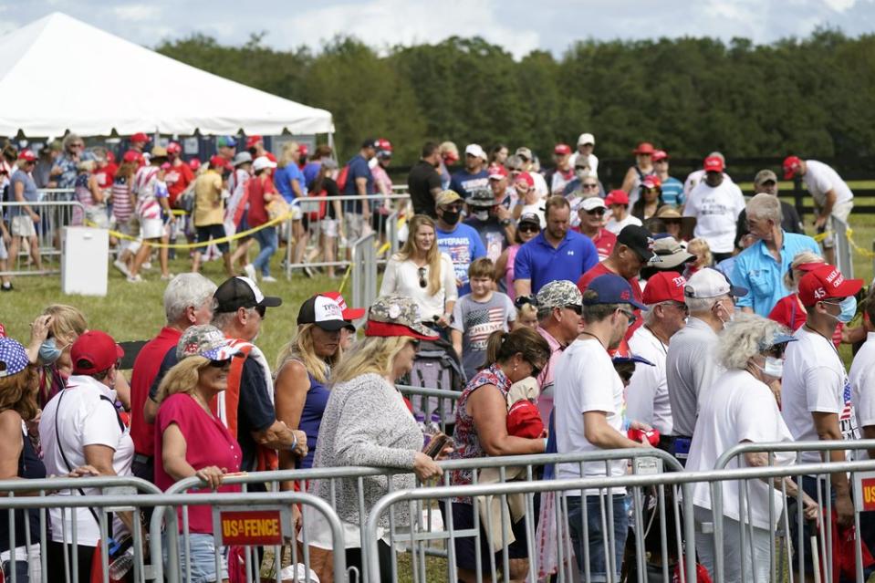 Audience members are seen not socially distancing or wearing masks.