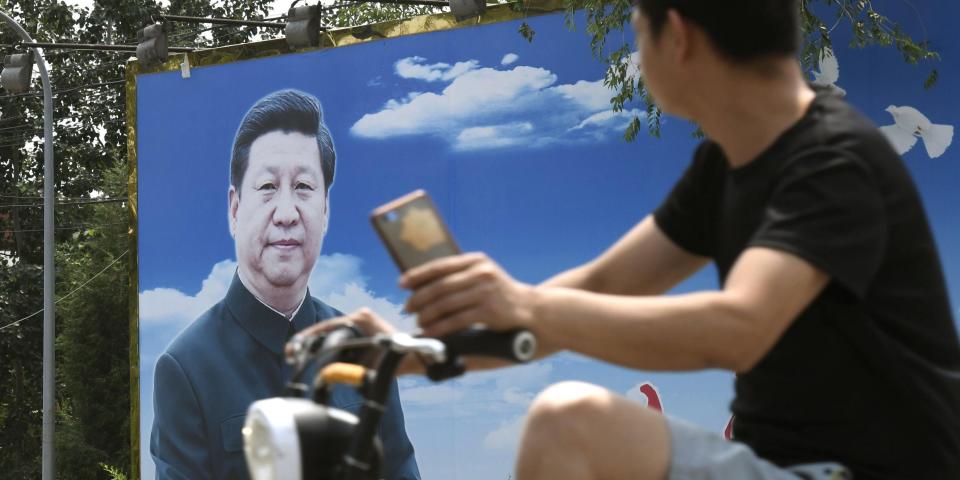 A man looks at a picture of Chinese President Xi Jinping in Beijing on June 20, 2020. (Photo by Kyodo News via Getty Images)