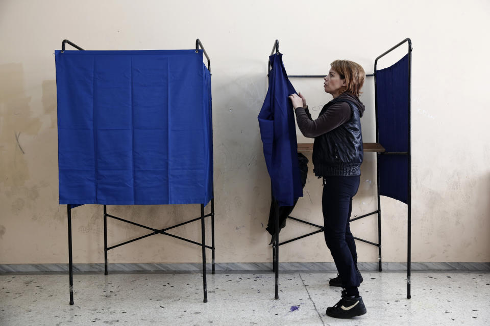 A municipal worker assembles voting booths at a voting center, in Athens, Friday, Jan. 23, 2015.  (AP Photo/Petros Giannakouris)