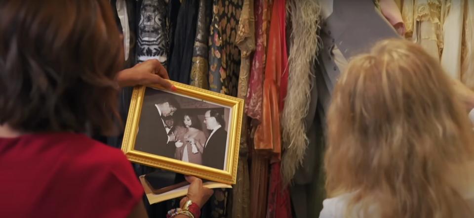 Gayle King and Barbra Streisand looking at a framed photo of a young Streisand and President John F. Kennedy.