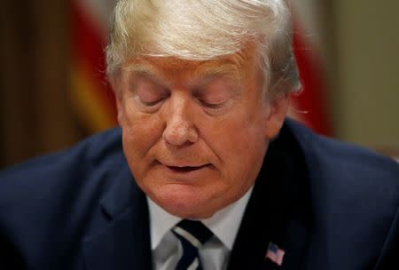 U.S. President Donald Trump reds from prepared remarks as he speaks about his summit meeting with Russia's President Vladimir Putin at the start of a meeting with members of the U.S. Congress at the White House in Washington, July 17, 2018. REUTERS/Leah Millis