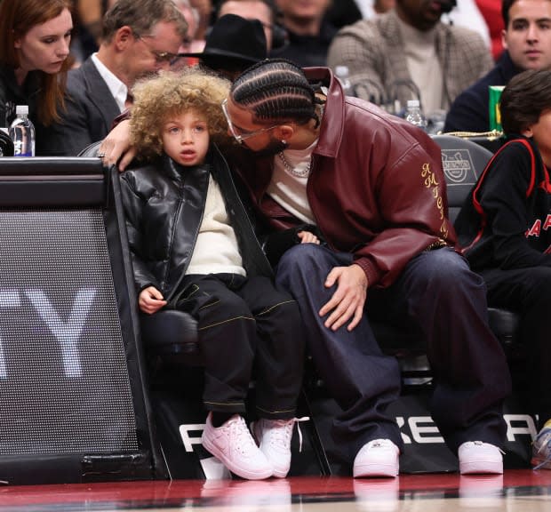 Drake and son Adonis, 5, match in leather jackets at basketball game