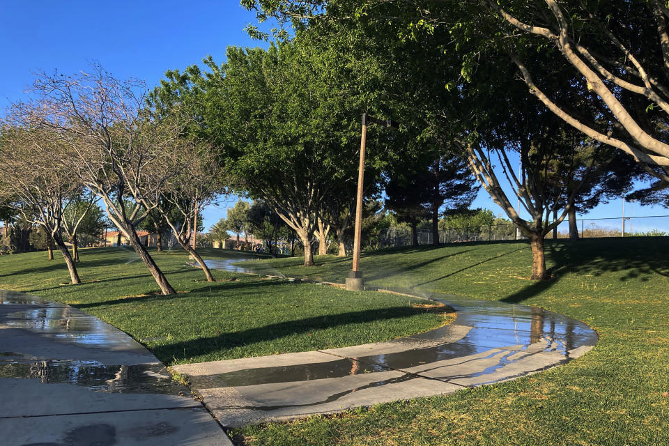 FILE - Sprinklers water grass at a park on Friday, April 9, 2021, in the Summerlin neighborhood of Las Vegas. In November 2022, some of the largest water agencies in the western United States agreed to a framework that would dramatically reduce the amount of decorative grass in cities such as Los Angeles, Las Vegas, Salt Lake City and Denver. The agreement comes as the seven states that rely on the overtapped Colorado River are facing a dire future with less water to go around. (AP Photo/Ken Ritter, File)