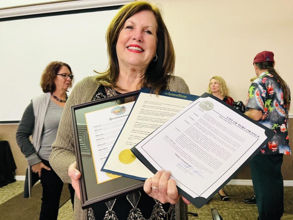 Debbie Connors holds up proclamations she received from the mayors of Port Orange, South Daytona and Daytona Beach Shores at her retirement party after 22 years of service as CEO of the Port Orange South Daytona Chamber of Commerce on Wednesday evening, Dec. 21, 2022.