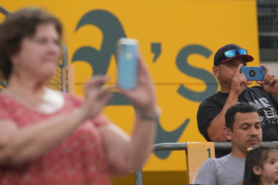 Parents film their children during the opening ceremony for Baseball for All, an organization focused on giving girls an opportunity to play baseball, at Hohokam Stadium in Mesa, Ariz. on Wednesday, July 20, 2022. 