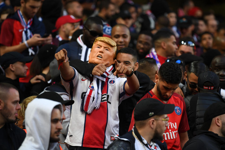 <p>Non, vous ne rêvez pas, un supporter parisien a bien enfilé le masque de Donald Trump pour assister à Liverpool-PSG. (crédit Getty) </p>