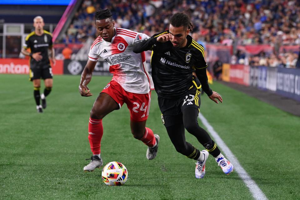 Jun 29, 2024; Foxborough, Massachusetts, USA; New England Revolution defender DeJuan Jones (24) and Columbus Crew defender Mohamed Farsi (23) battle for the ball near the sideline during the second half at Gillette Stadium. Mandatory Credit: Eric Canha-USA TODAY Sports