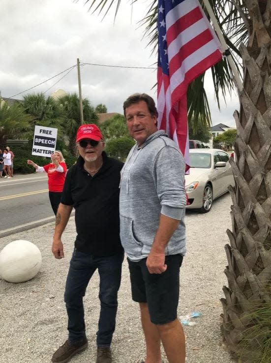 Marvin Peavy, right, stands with a supporter last year outside his Seagrove Beach home on Walton County Road 30A. Peavy has appealed a Walton County code magistrate ruling ordering that pro-Trump banners be taken down from the side of the residence where he spends part of each week.