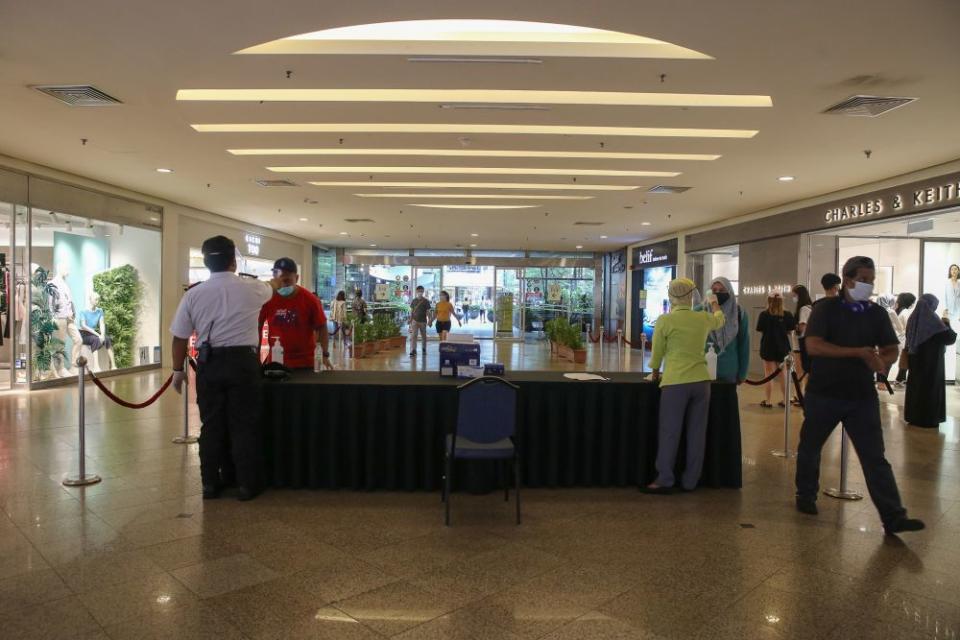 Security personnel check patrons' temperature at the Mid Valley Megamall in Kuala Lumpur May 28, 2020. — Picture by Yusof Mat Isa