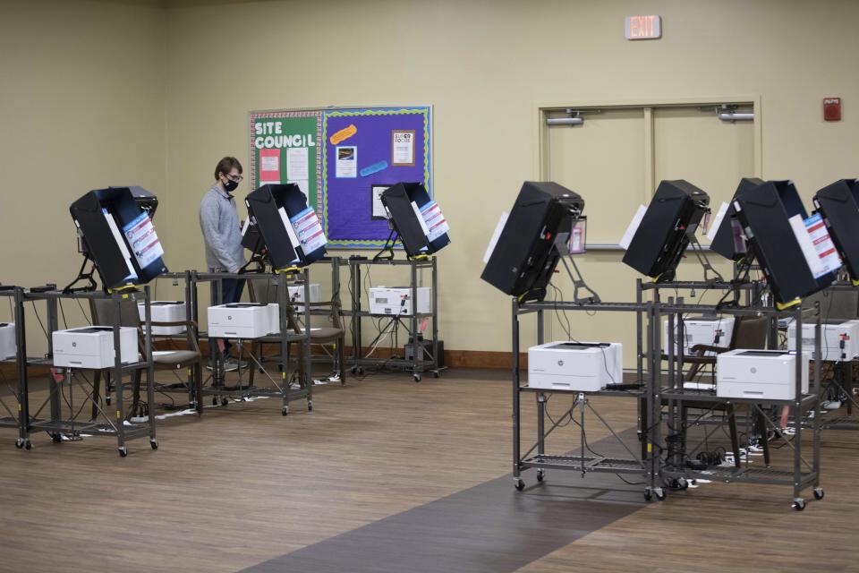 A man votes on the only machine working shortly after polls opened in Georgia's Senate runoff elections at a senior center, Tuesday, Jan. 5, 2021, in Acworth, Ga. Election systems in the U.S. are vulnerable to cyber intrusions similar to the one that hit federal agencies and numerous businesses last year and remain a potential target for foreign hacking, according to a report released Wednesday, Feb. 10, 2021. (AP Photo/Branden Camp, file)