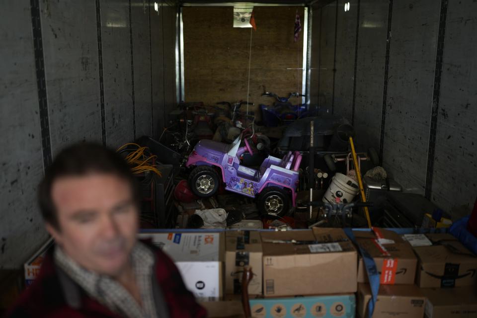 Ron Caetano stands in a trailer packed with his family's belongings in anticipation of flooding of the Kings River in the Island district of Lemoore, Calif., Wednesday, April 19, 2023. Caetano packed photos and valuables in a trailer and food in carry totes so he can leave home in less than an hour should the river water rush in. (AP Photo/Jae C. Hong)