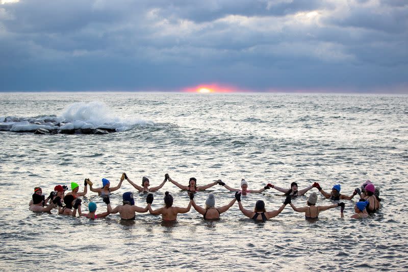 Women bathe in the chilly waters of Lake Ontario during freezing temperatures in Toronto