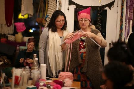 Molly Cleator teaches Crystal Ho to knit as they take part in the Pussyhat social media campaign to provide pink hats for protesters in the women's march in Washington, D.C., the day after the presidential inauguration, in Los Angeles, California, U.S., January 13, 2017. REUTERS/Lucy Nicholson