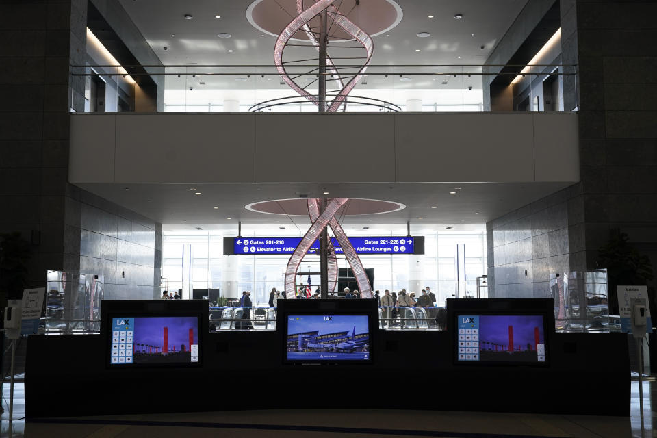 A chandelier hangs behind interactive kiosks at the new West Gates at Tom Bradley International Terminal at Los Angeles International Airport Monday, May 24, 2021, in Los Angeles. (AP Photo/Ashley Landis)