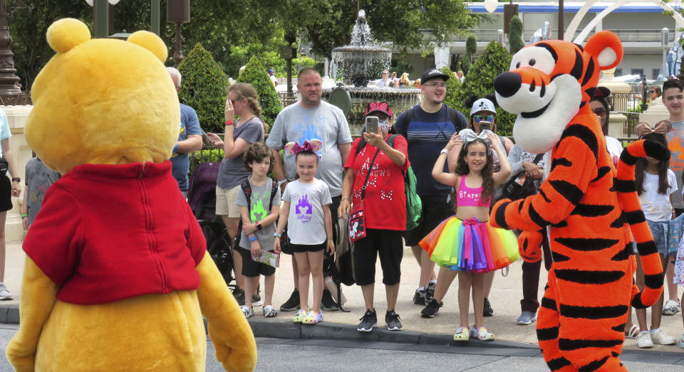 Young guests enjoy seeing Winnie The Pooh, and Tigger too, at the Magic Kingdom at Walt Disney World, in Lake Buena Vista, Fla., Monday, May 17, 2021, after Disney Co. eased face mask requirements over the weekend. Guests are allowed to go maskless in outdoor areas of the parks. Indoor attractions, shops and Disney transportation at the resort all still require masks. (Joe Burbank/Orlando Sentinel via AP)